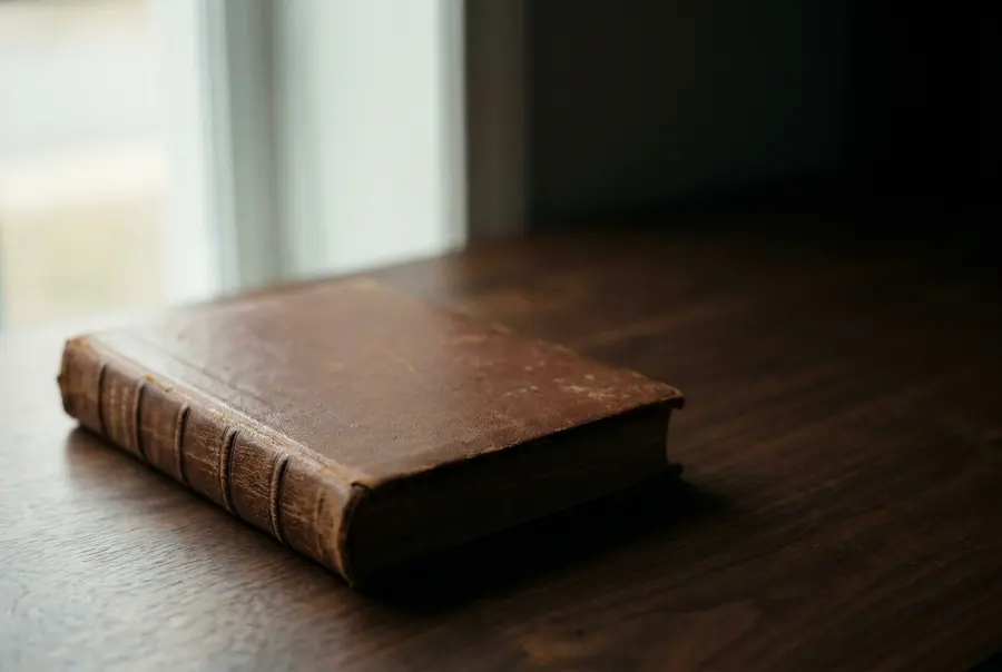 Livro de atas encadernado em couro sobre mesa de nogueira